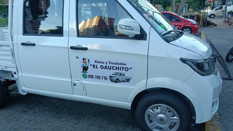 Imán vehicular de empresa de fletes con dibujo de gaucho en la puerta de una camioneta blanca