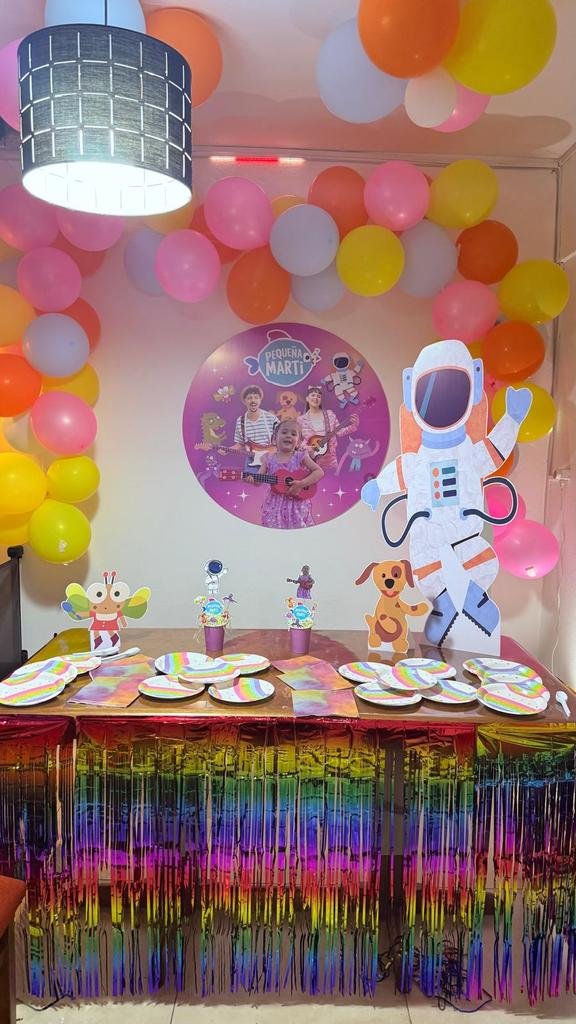 Kit de cumpleaños temática Pequeña Marti con círculo de foto, figuras y globos de colores sobre la mesa
