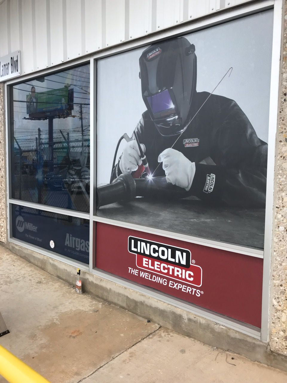 Vinilo adhesivo grande en ventana industrial