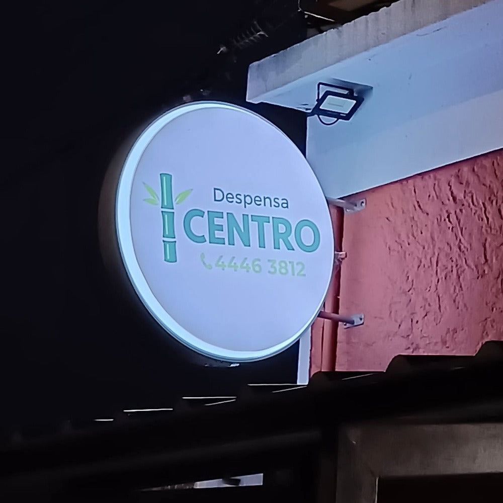 Cartel luminoso redondo de Despensa Centro instalado en una fachada.