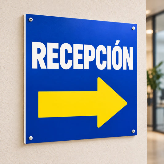Imagen conceptual de un cartel de señalética en Sintra azul con la palabra «RECEPCIÓN» y una flecha amarilla impresas, montado en pared con canto blanco visible.